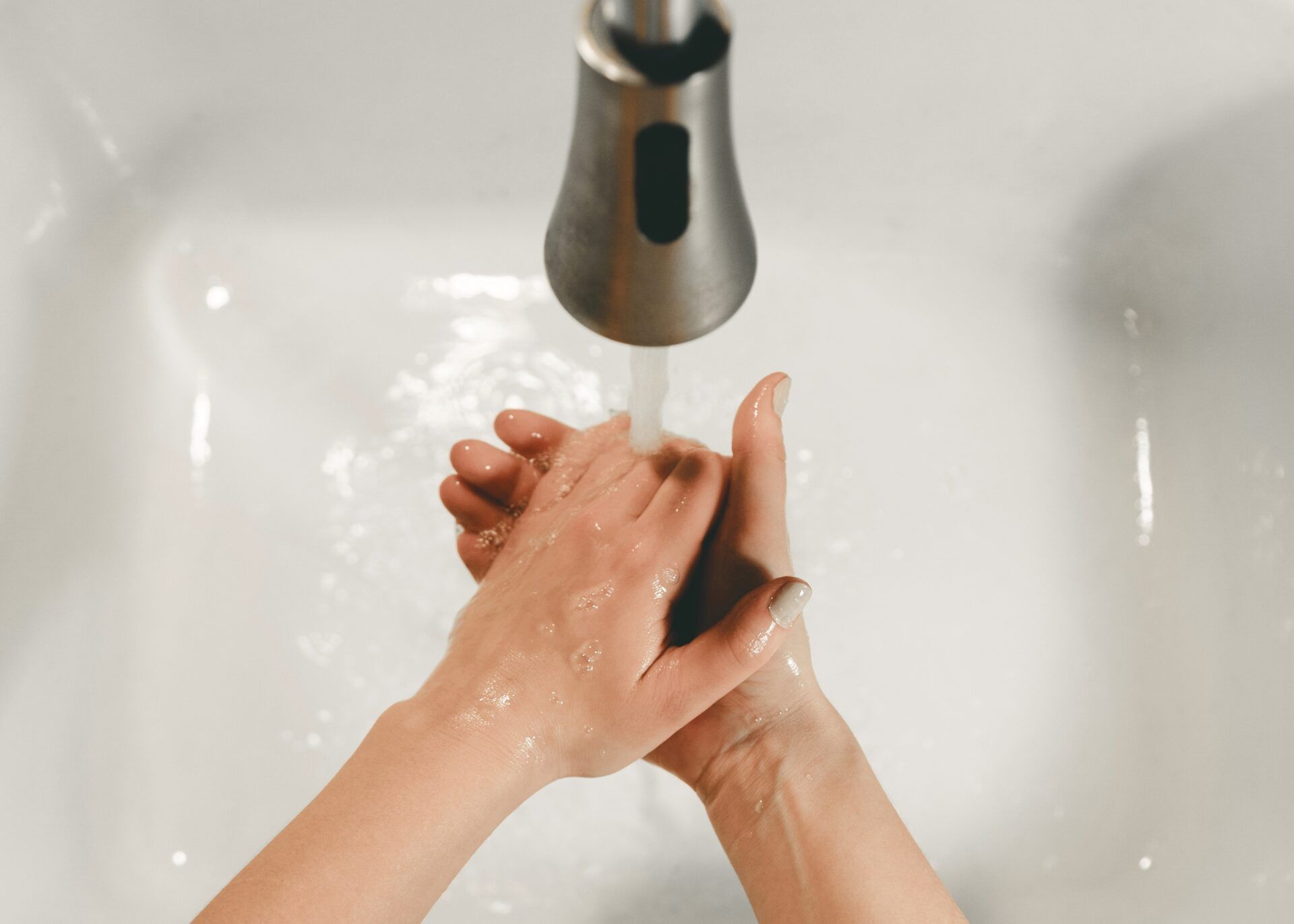 Hände, die unter dem Wasserhahn gewaschen werden